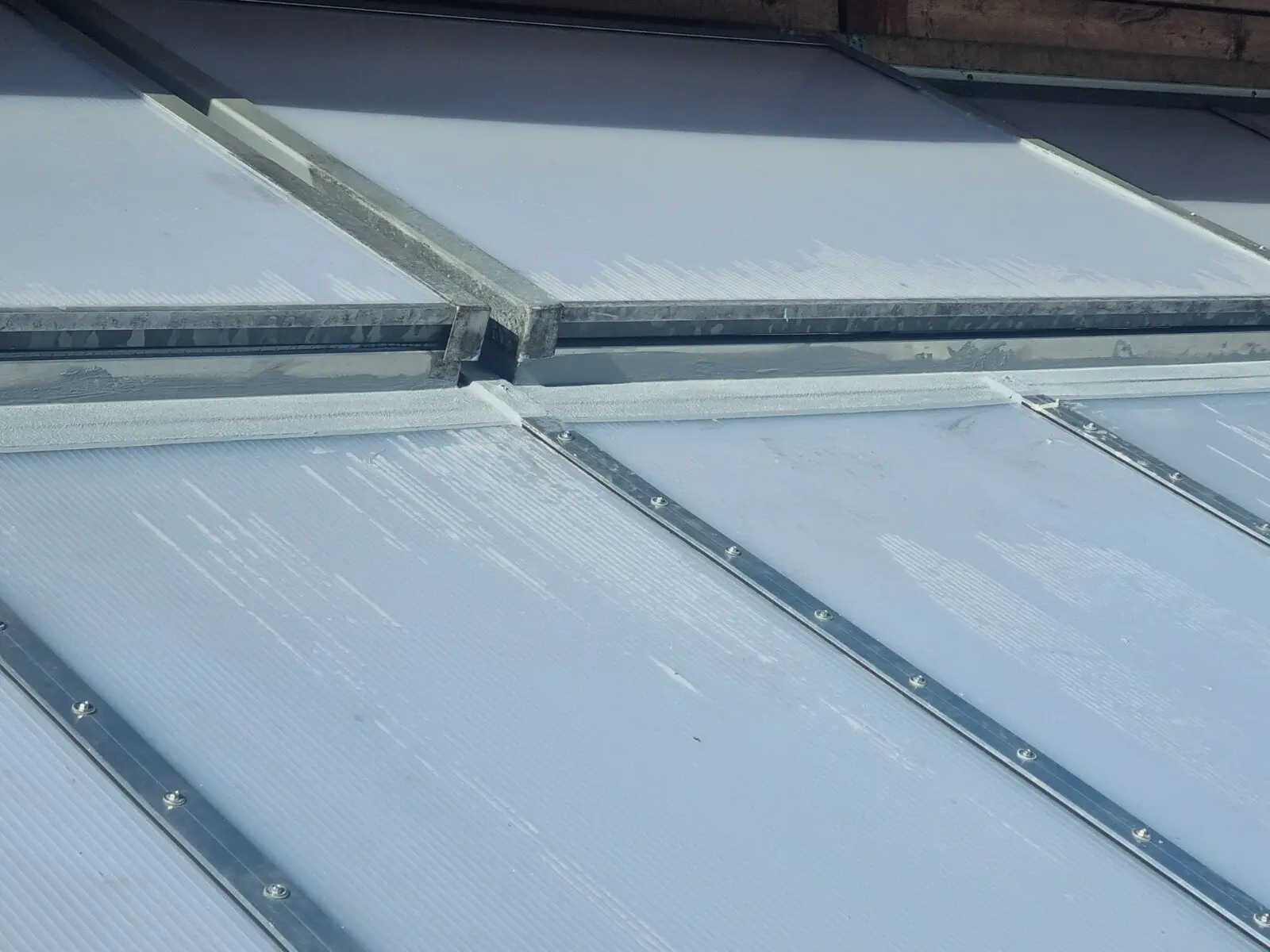 Glas- und Wellplattendach einer Terrassenüberdachung von unten